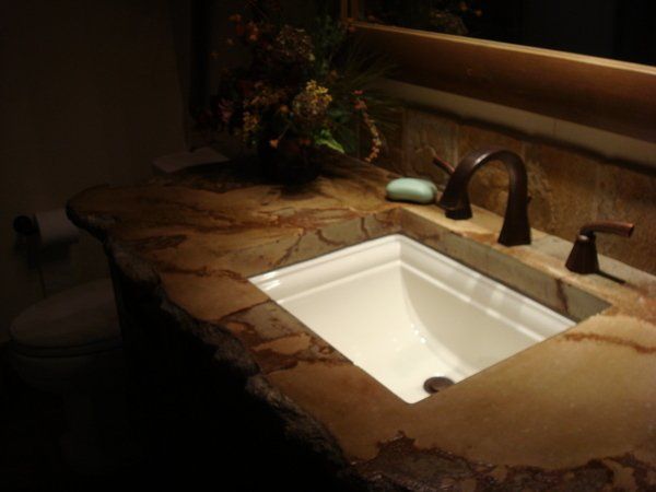 A bathroom sink with a brown counter top