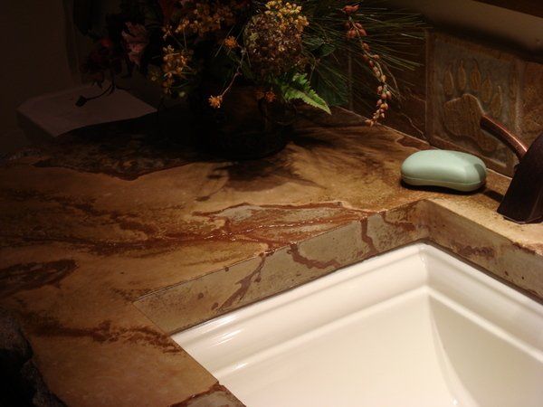 A bathroom sink with a soap bar and a vase of flowers on the counter.