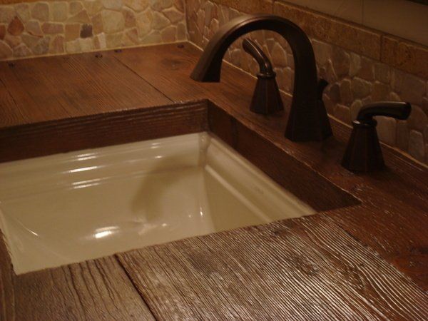 A bathroom sink with a wooden counter top