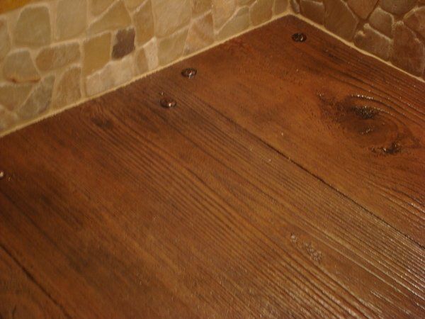 A close up of a wooden floor with screws in it