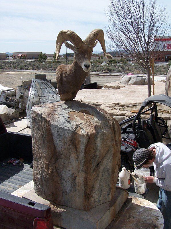 A statue of a ram sitting on top of a rock