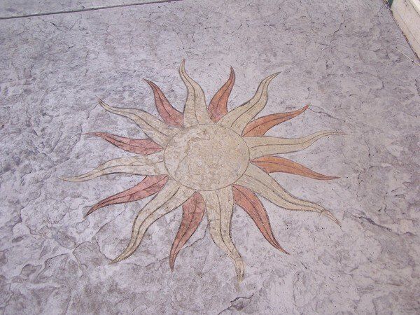 A concrete floor with a sun design on it