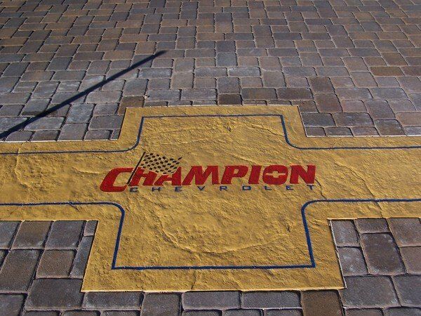 A yellow and red champion logo on a brick floor