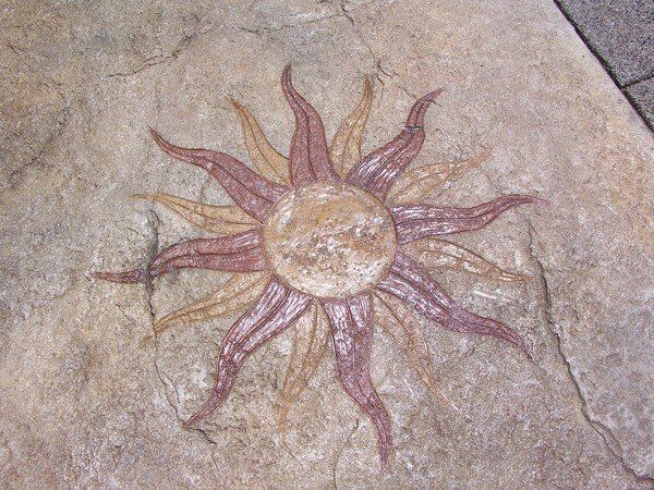 A painting of a sun on a rock