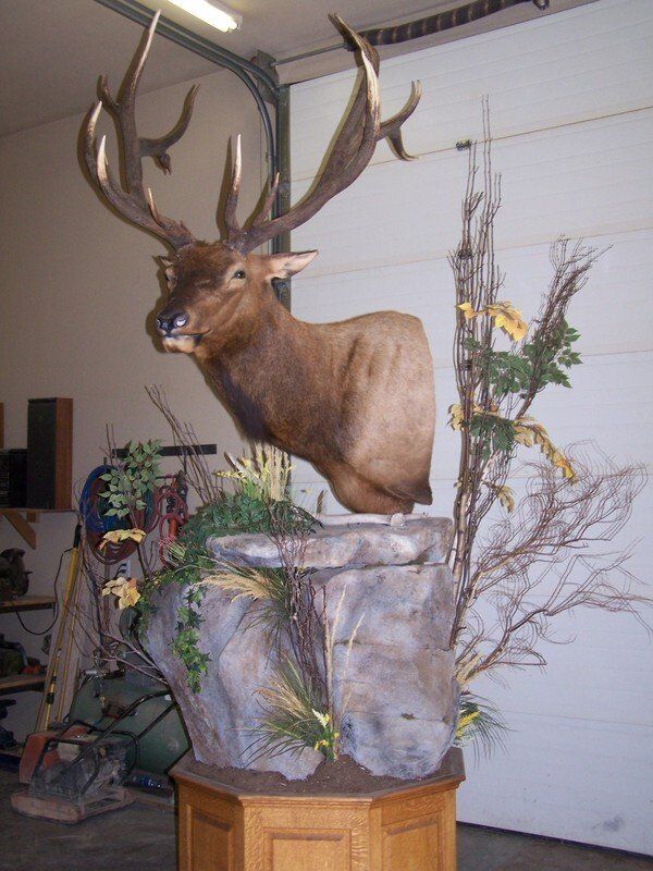 A statue of a deer hanging from a tree branch