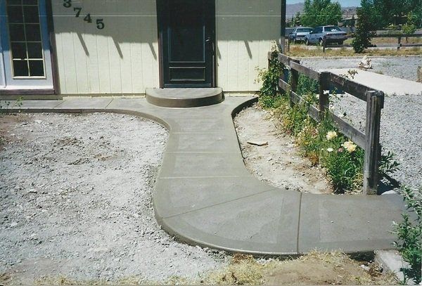 A concrete walkway leading to the front door of a house