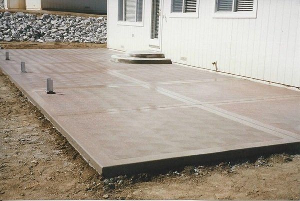 A concrete patio in front of a white house