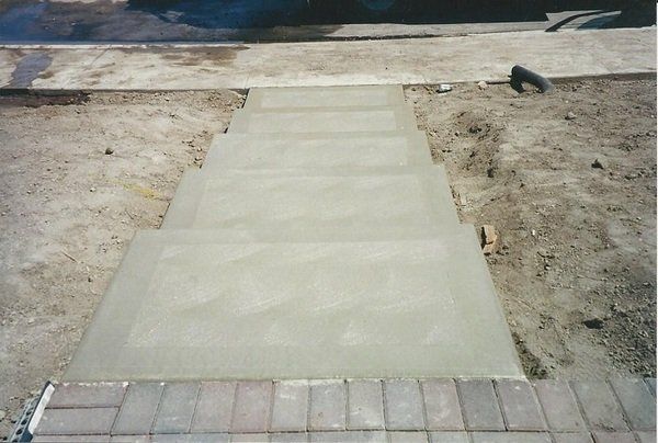 A concrete walkway is being built next to a brick walkway