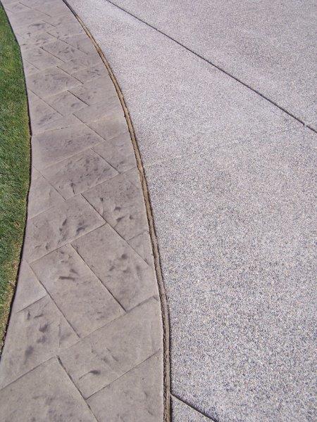A close up of a concrete walkway with a grassy border