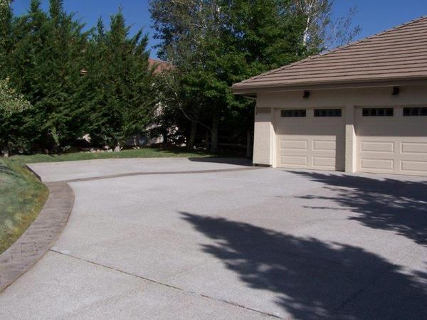 A driveway leading to a house with two garage doors