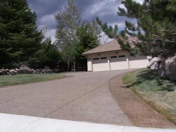 A driveway leading to a house with two garages