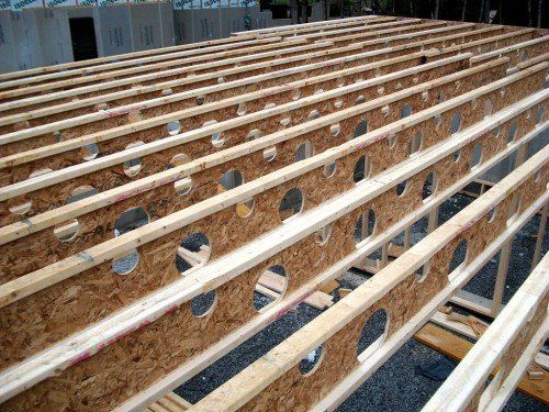 Solives de plancher en bois avec trous circulaires, faisant partie de la charpente d'un bâtiment, vues de biais.