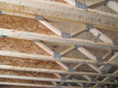 Charpente de toit en bois avec connecteurs métalliques, revêtement en panneaux OSB.