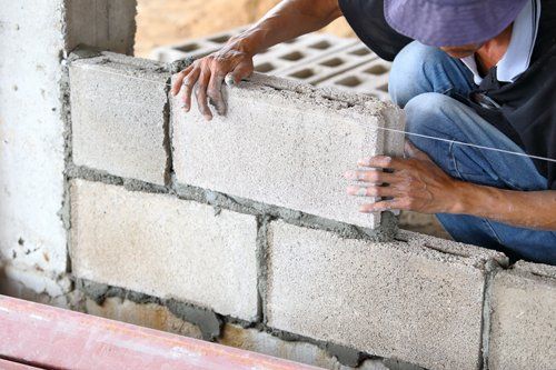 un costruttore che mette assieme dei mattoni per un muro