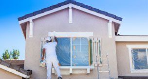 Exterior Re-Painting — Worker painting window outside the house in Carson City, NV Exterior Re-Painting — Worker painting window outside the house in Carson City, NV
