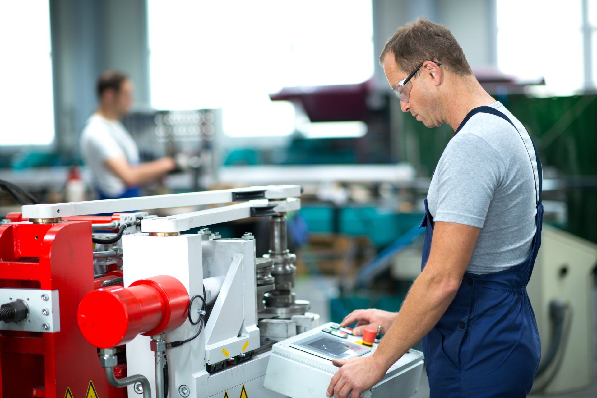 Ein Mann arbeitet in einer Fabrik an einer Maschine.