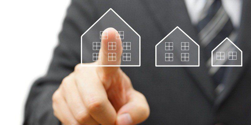 Businessperson touching house icons on a digital interface