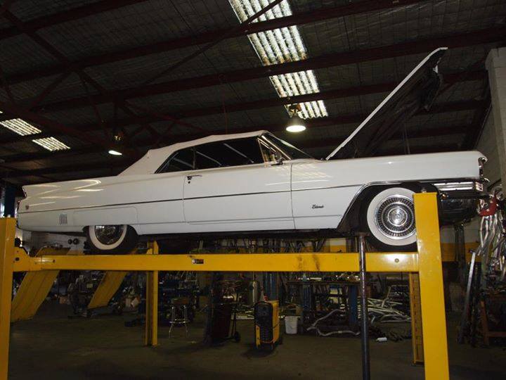 white car on lift with hood open