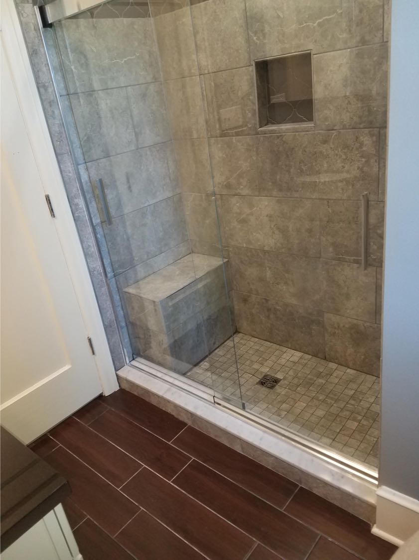 This bathroom floor and shower combine multiple colors and textures