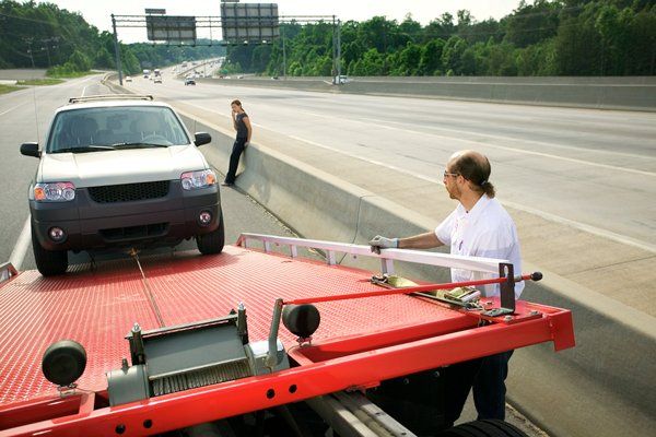 Roadside Assistance — Tow Truck Driver Loading Car in Medford, OR Roadside Assistance — Tow Truck Driver Loading Car in Medford, OR