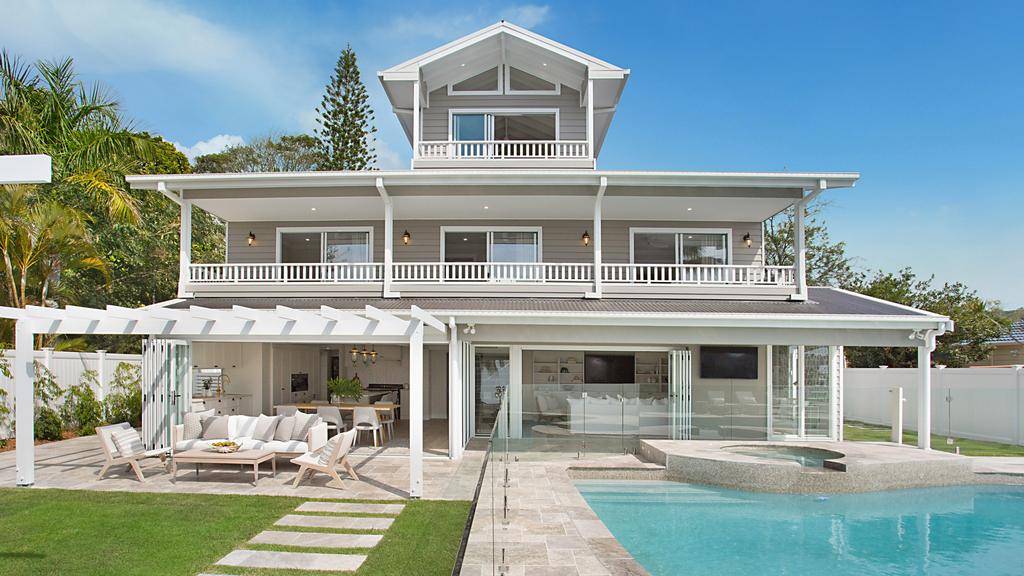 A large house with a swimming pool in front of it.