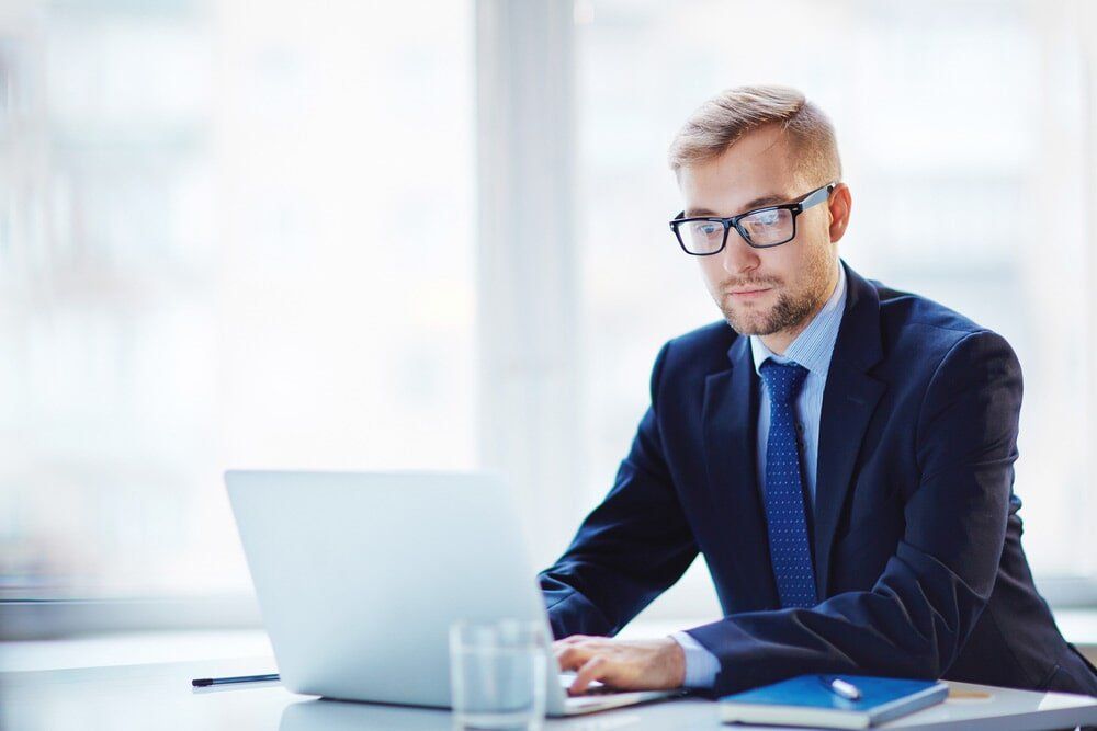 Man Working With Laptop — North Coast Commercial Doors in Newcastle, NSW
