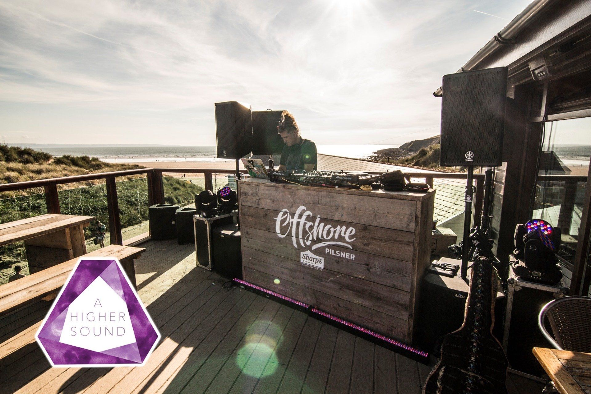 DJ at outdoor deck overlooking the ocean, playing at an