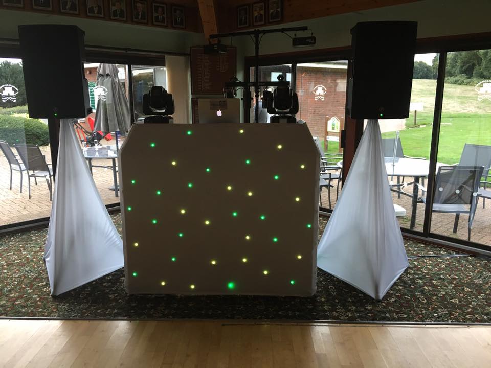 DJ setup with speakers, lights, and a star-lit facade on a patio.