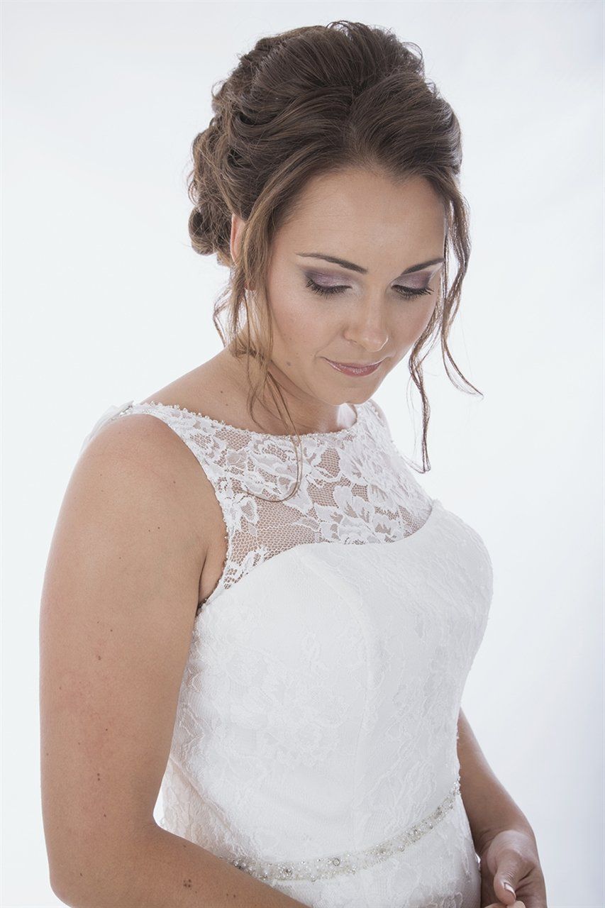 Woman in wedding dress, looking down with elegant updo.