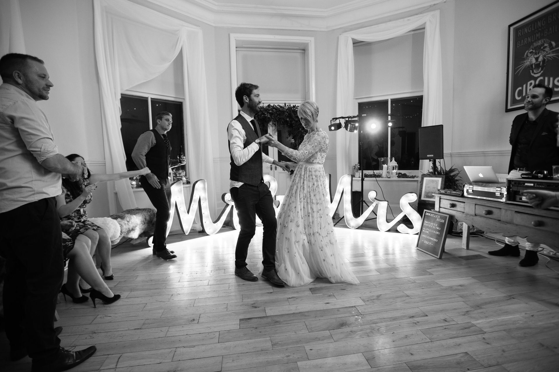 Newlyweds dance at reception, illuminated