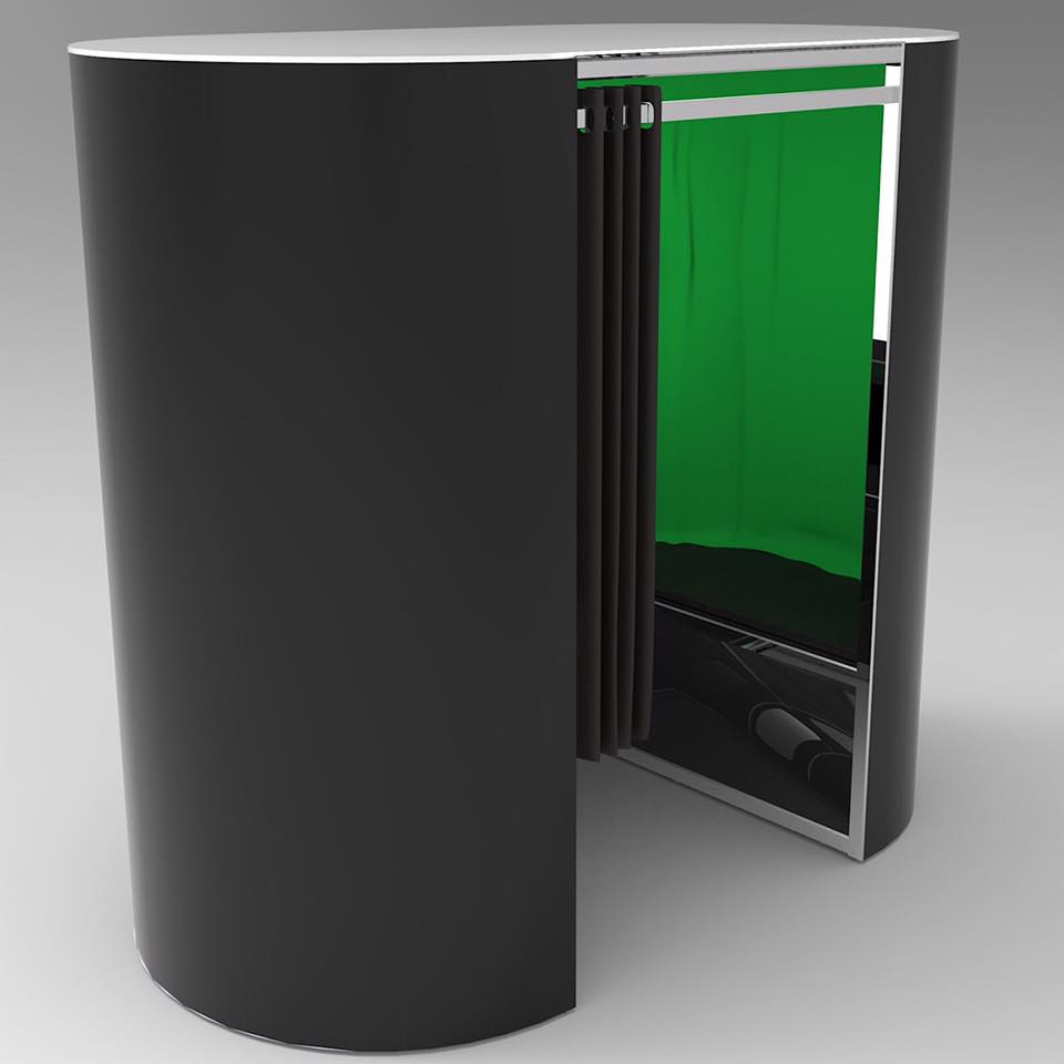 Black photo booth with green screen inside; silver trim and sliding door.