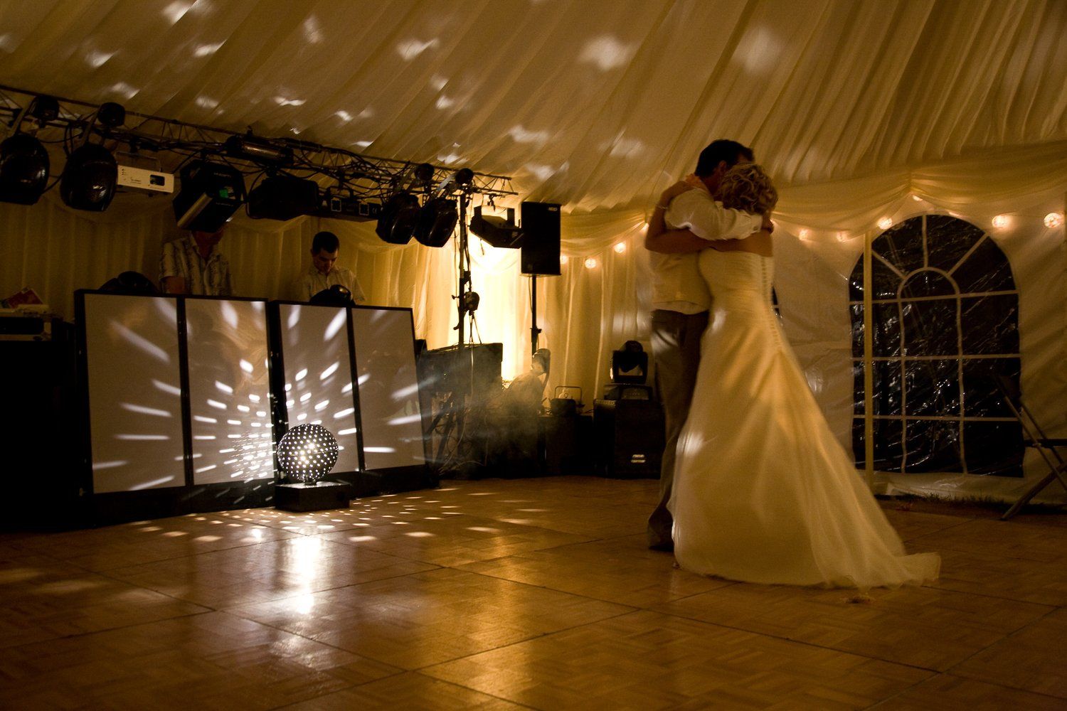Couple dances at a wedding reception under disco lights.