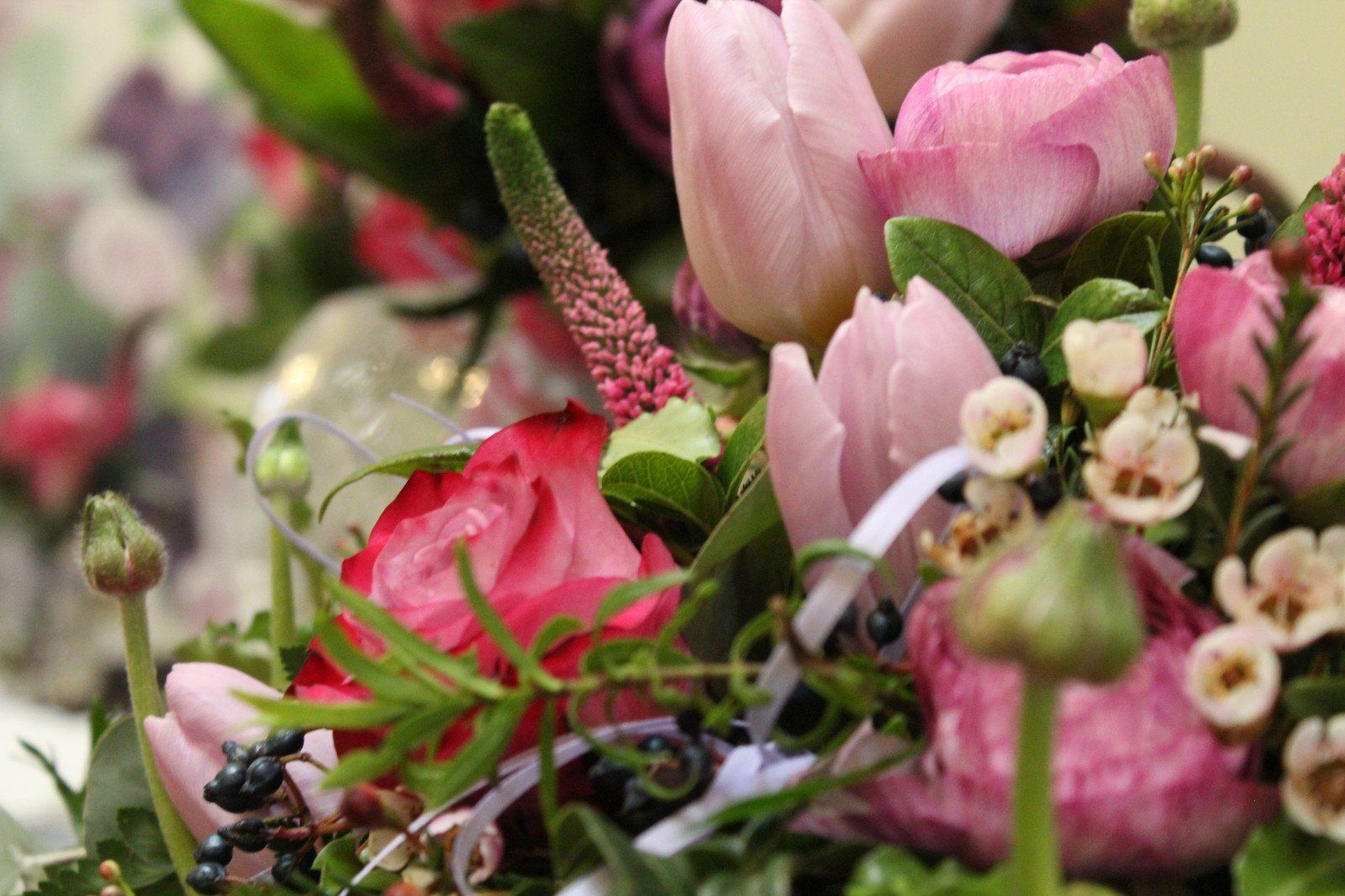 Close-up of a bouquet with pink tulips, roses, and other flowers.