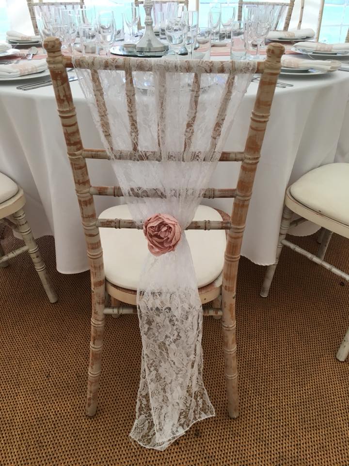 Chair with lace and floral decoration at a wedding table setting.