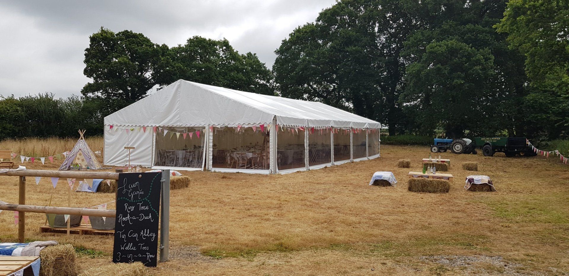A white tent set up on a dry grassy field, possibly for an outdoor event.