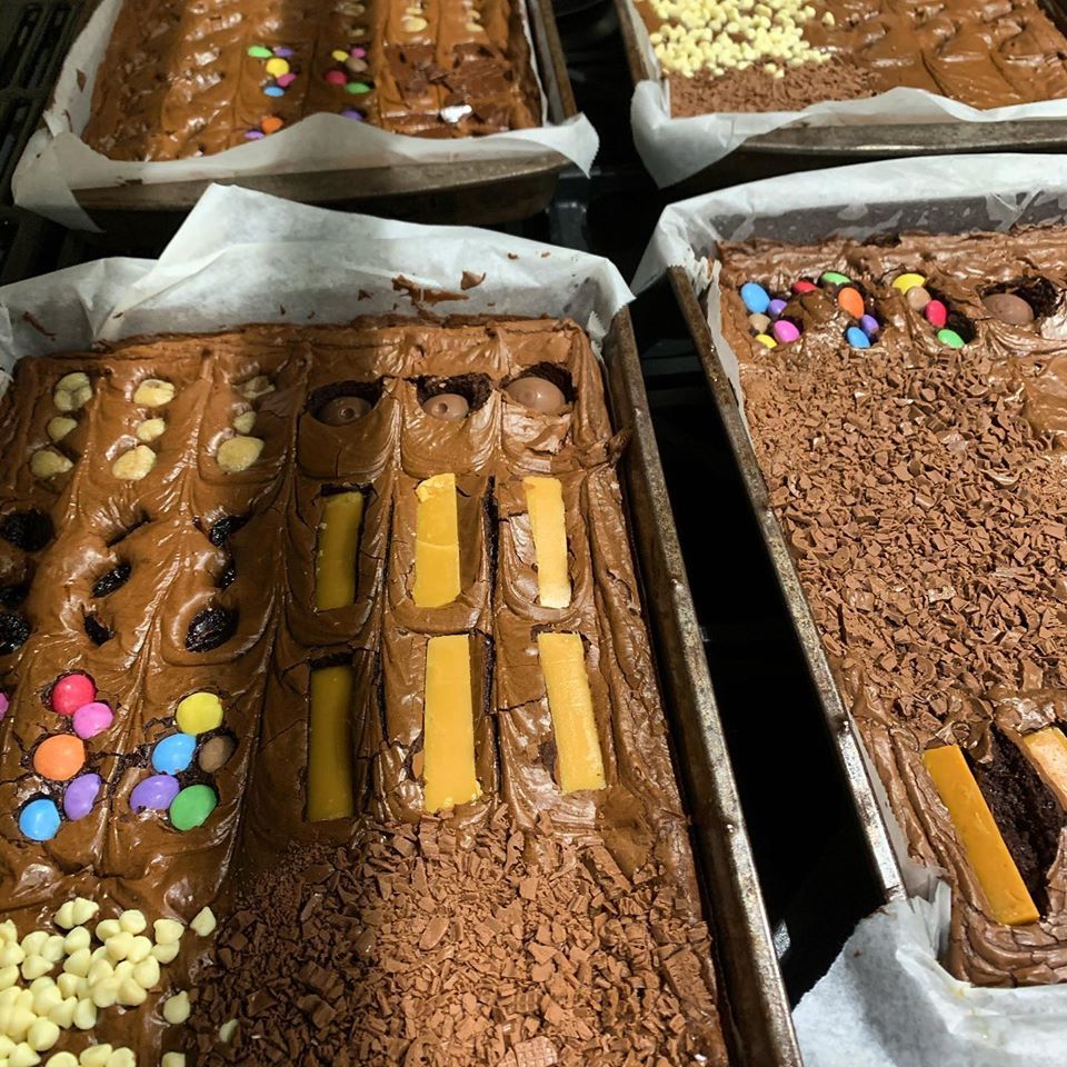 Several brownie trays with various toppings, including candy, chocolate shavings, and caramel.