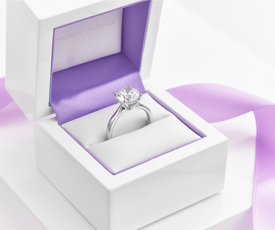 Diamond ring in a white box with a purple satin lining.