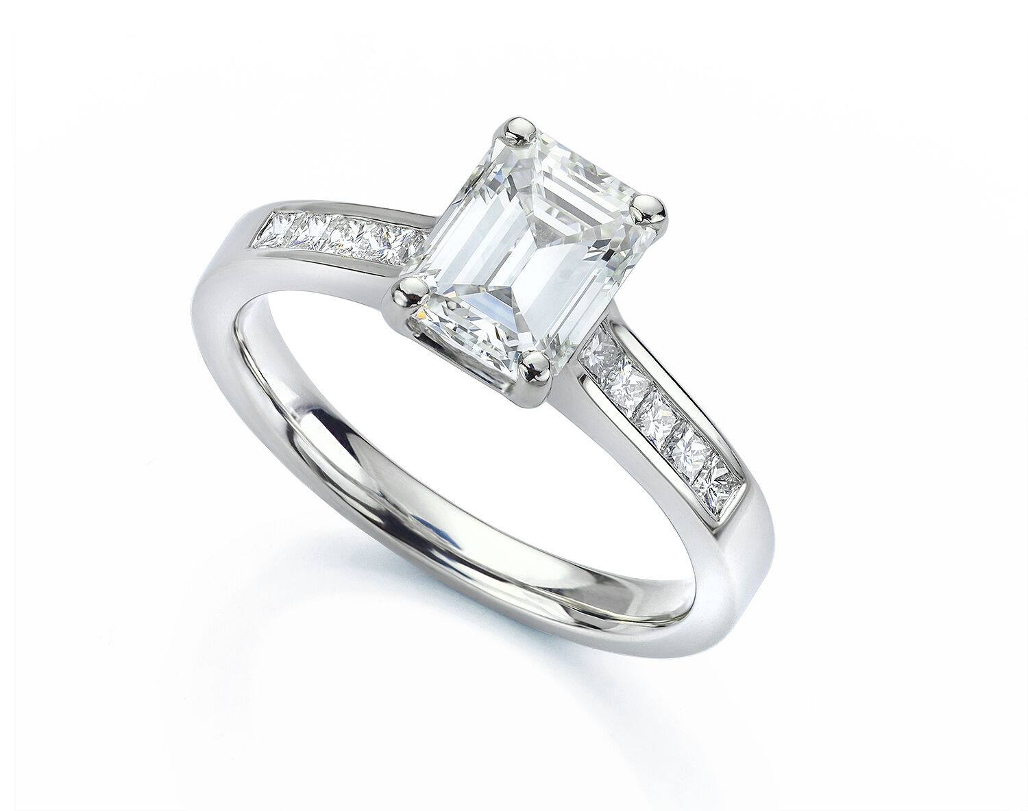 Diamond engagement ring with emerald-cut center stone and pave-set diamonds on the band.