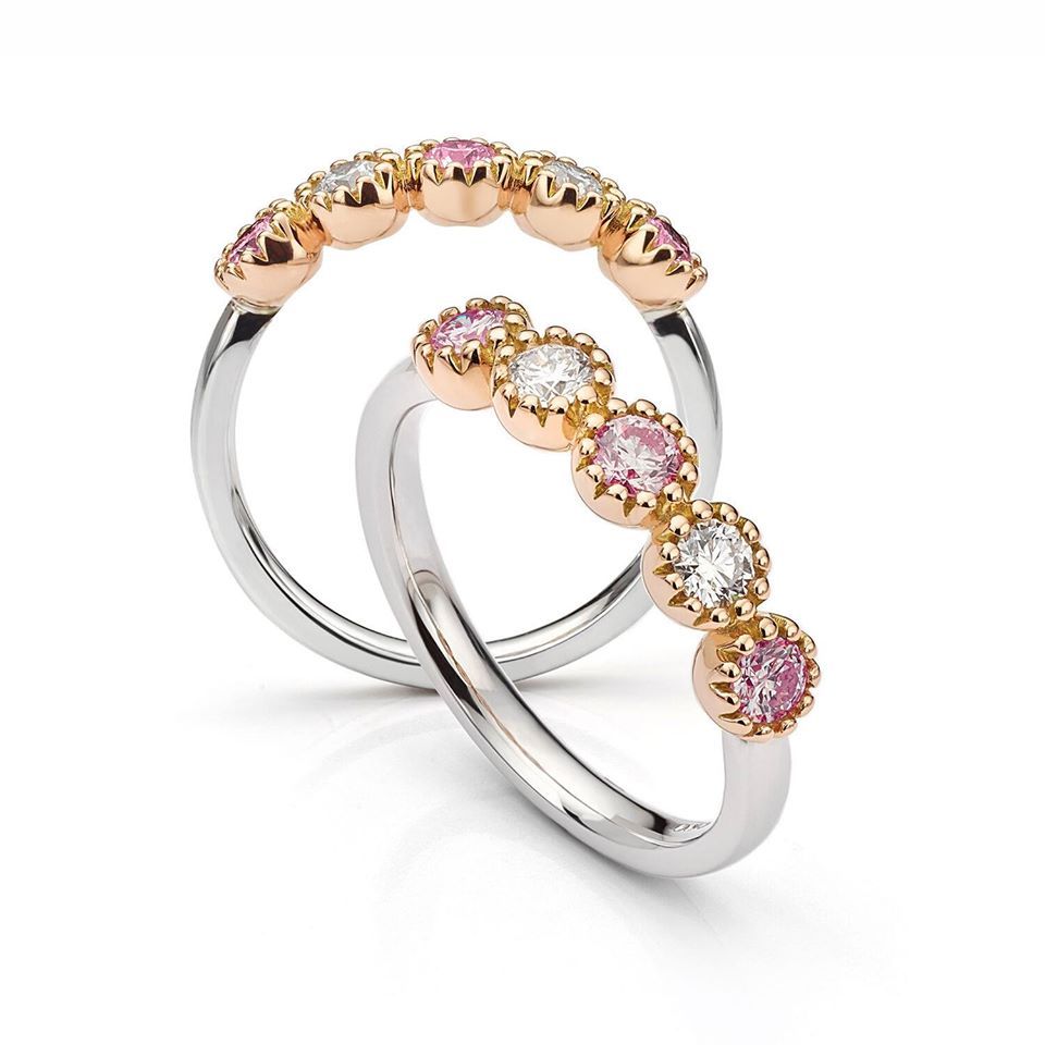 Two rings with pink and white gemstones set in gold bezels on silver bands.
