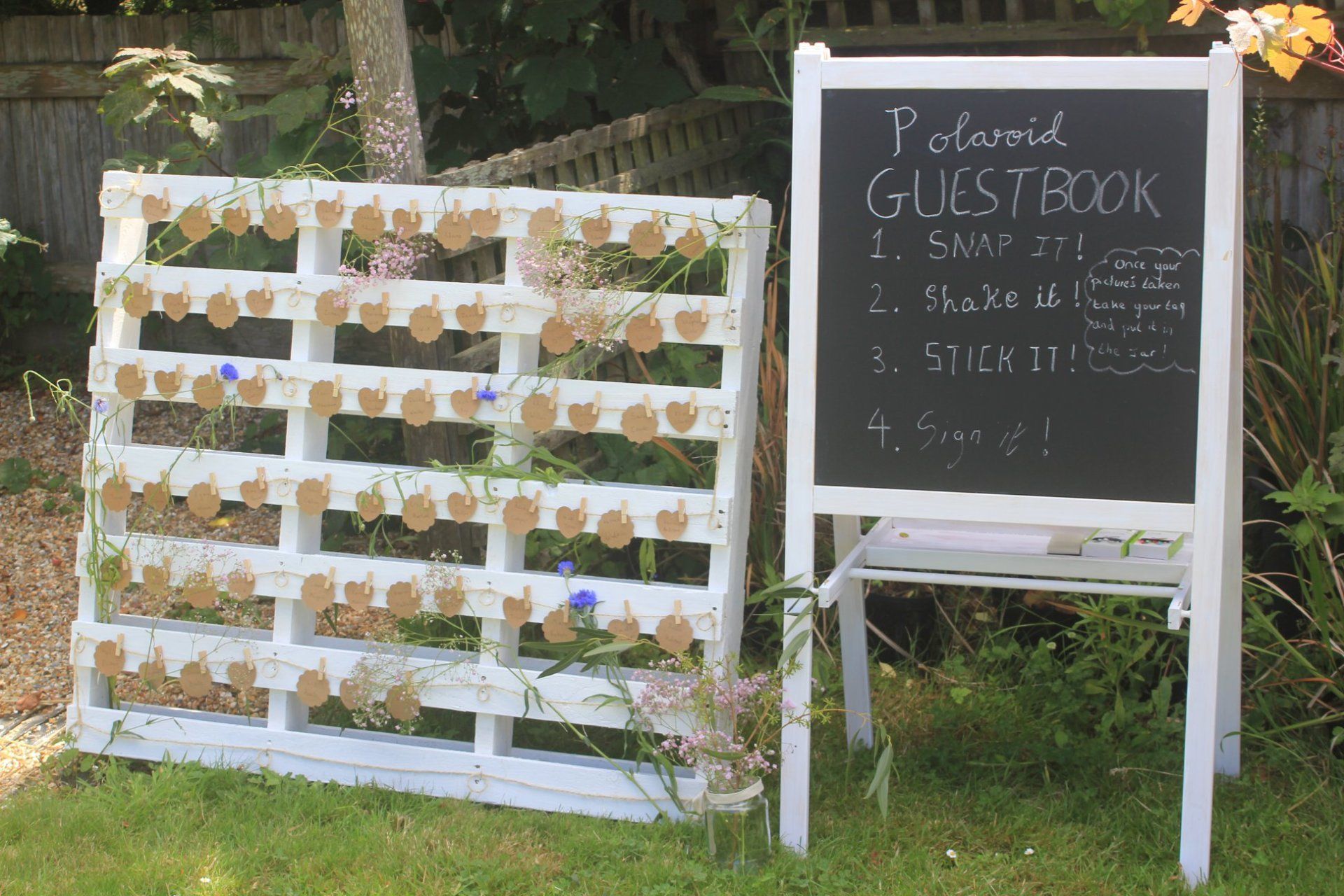 White pallet with attached tags and chalkboard sign that reads