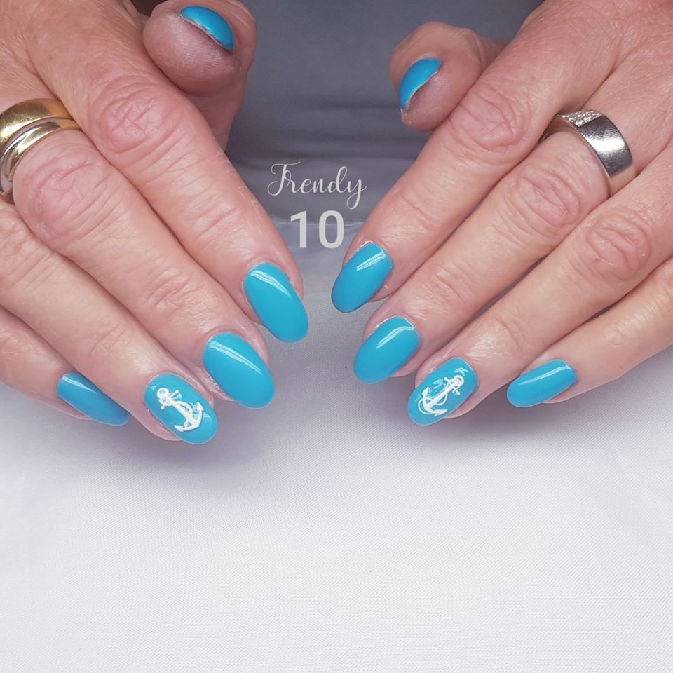 Hands with turquoise nails, two featuring white anchor designs.
