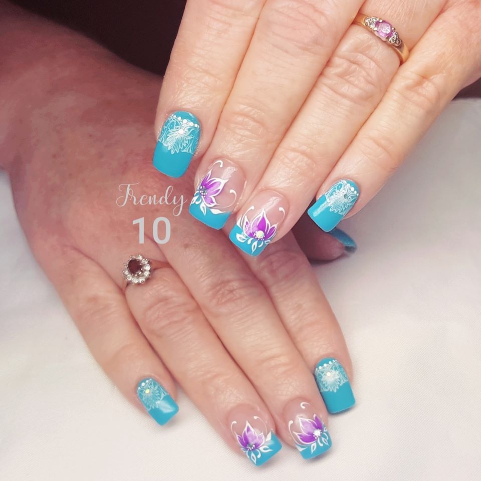 Hands with teal and floral nail art.