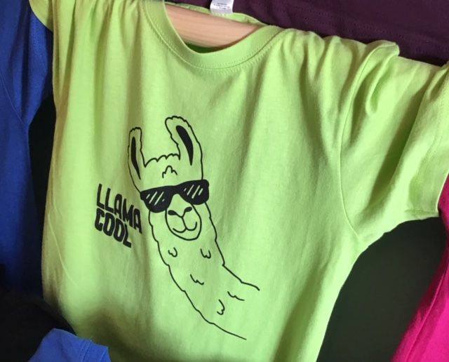 Lime green t-shirt with a cartoon llama wearing sunglasses, text reads 