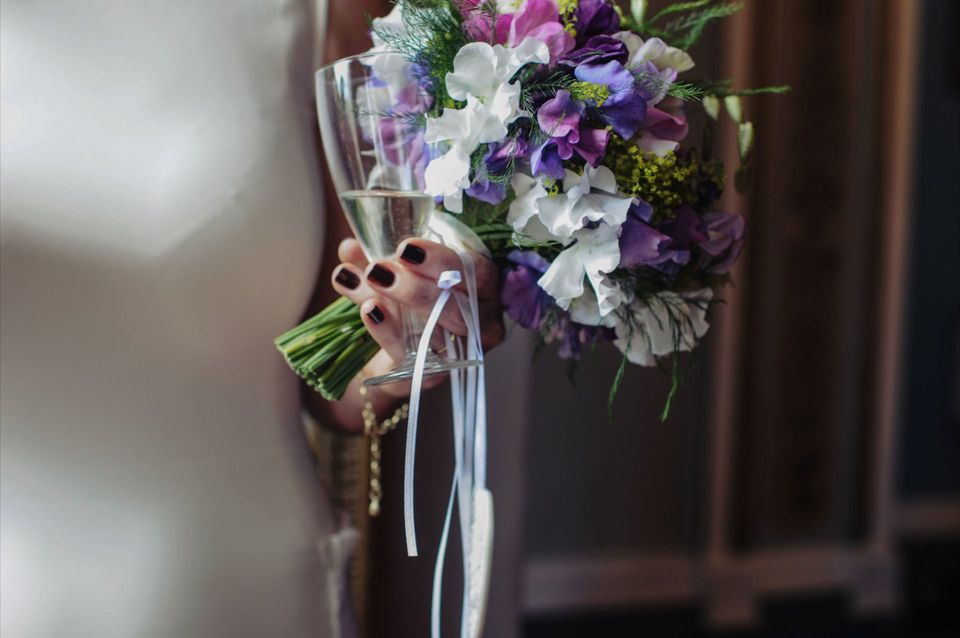 Wight Wedding Days | Your bouquet - to throw or not to throw? Bride holding her bouquet and a glass of bubbly