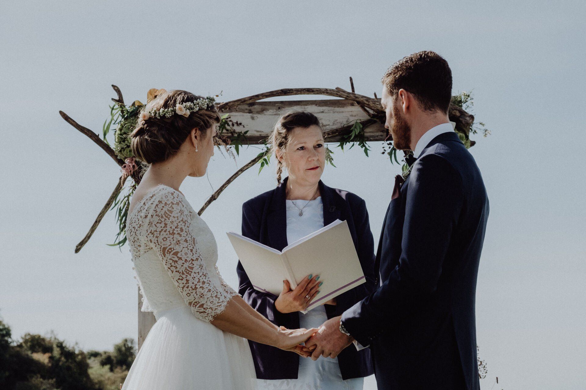 Couple exchanging vows at outdoor wedding ceremony.