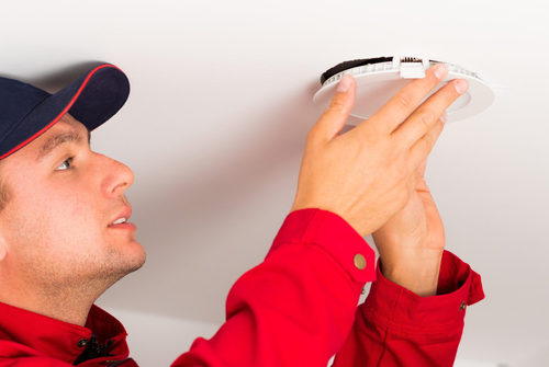 man changing light fixture