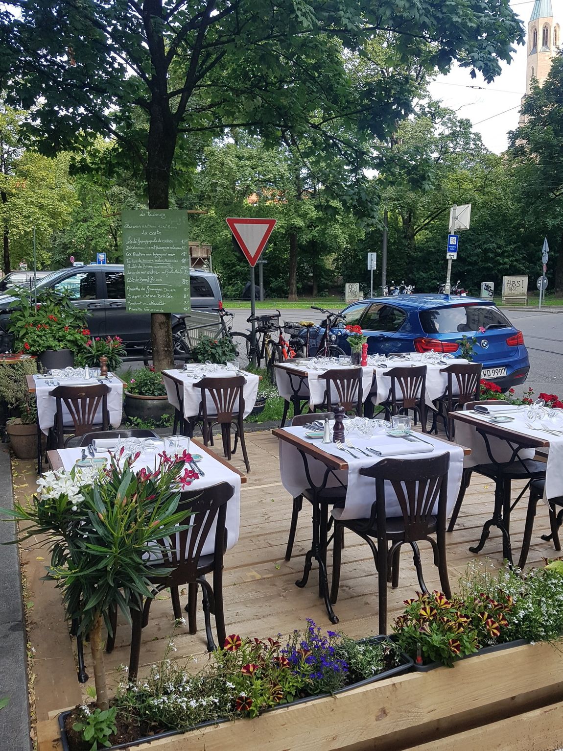 Ein Restaurant mit Tischen und Stühlen auf einem Parkplatz.