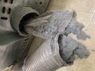2 Dryer Vents with large pile of dust pulled out