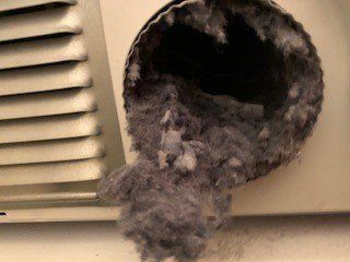 dryer vent filled with dust, spilling out