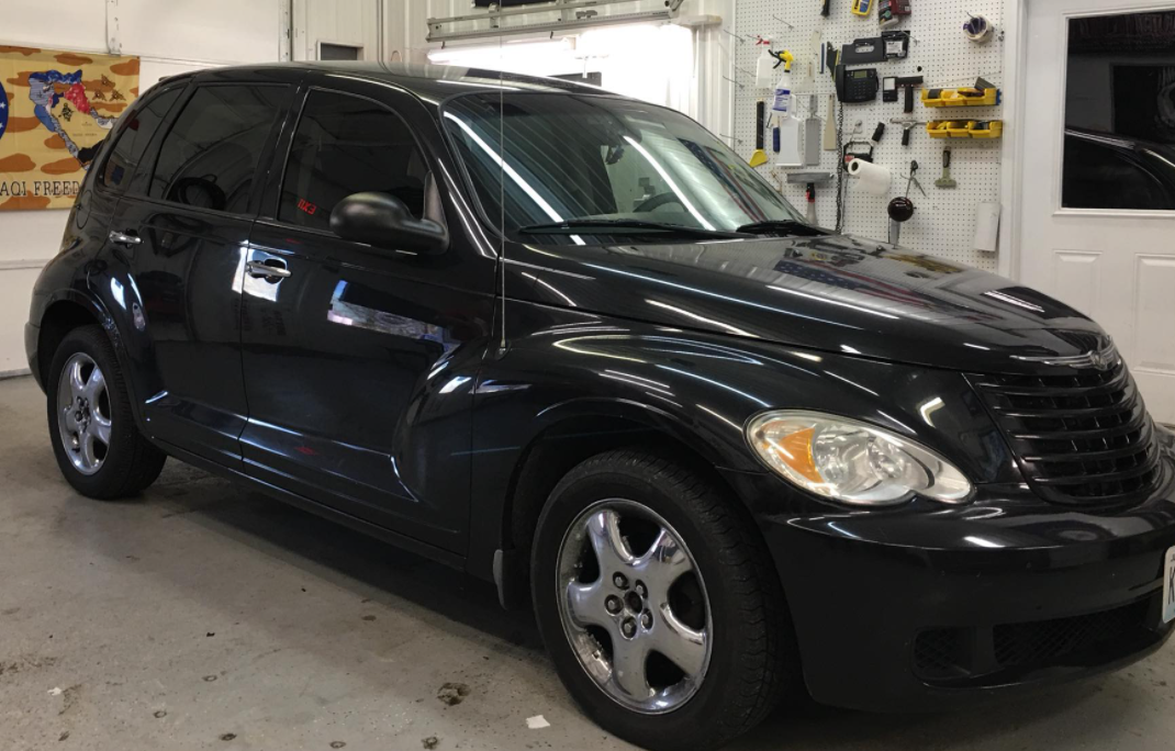 Black Chrysler PT Cruiser parked inside an auto shop garage